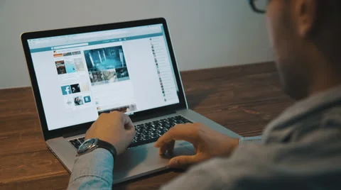 Man viewing the facebook social network on a laptop Stock Footage 54364834