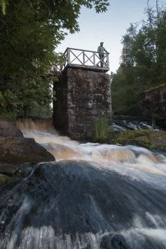 Man on a viewing platform over the ruins of an old hydroelectric power station Stock Photos