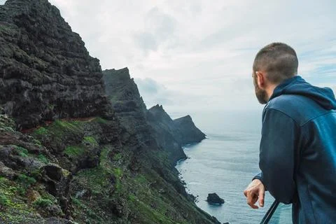 Man on a viewpoint watching the seascape in a cloudy day Stock Photos