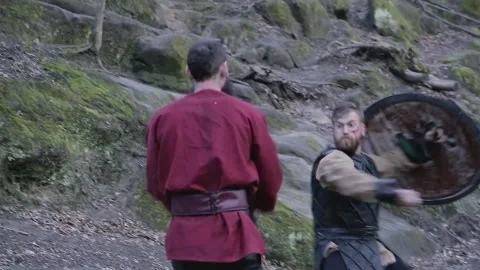 Man in Viking clothes with axes attacks another Viking with sword and shield Video stock 132992324