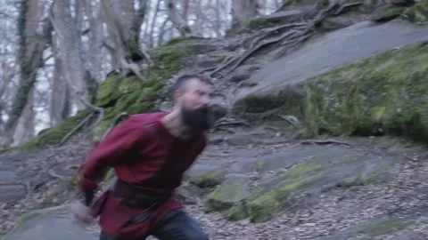 Man in Viking clothes with axes attacks another Viking with sword and shield Stock Footage 132992358