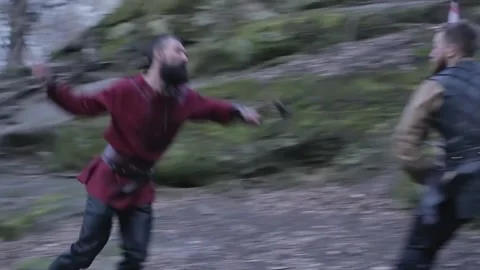 Man in Viking clothes with axes attacks another Viking with sword and shield Stock Footage 132992375
