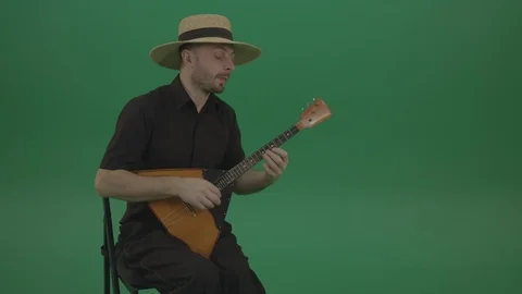 Man from village play Balalaika music instrument isolated on green screen Stock Footage