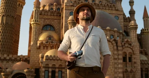 A man with a vintage camera stands against the background of the old mosque Stock Footage 151556599