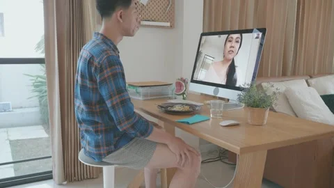A man Virtual Dating from VDO conference call with computer monitor in front of Video stock 314650145
