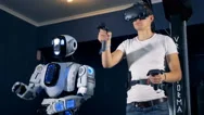 A Man In Virtual Reality Equipment Is Moving In Synch With A Robot Stock Footage