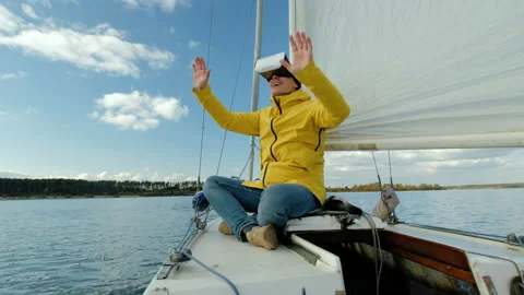 Man with Virtual Reality glasses, enjoying sitting on sailing boat and looking Stock Footage 85694364