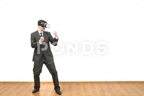 The man in a virtual reality glasses fighting on a white wall background Stock Photos