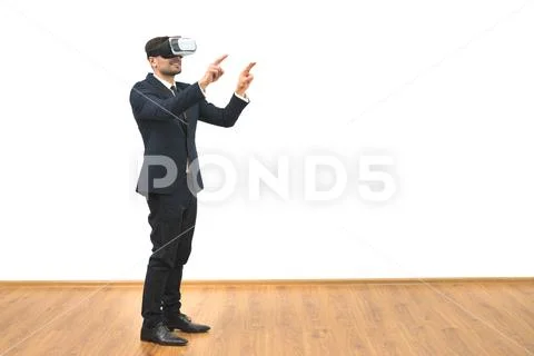 The man with a virtual reality glasses gesturing on the white wall background Stock Photos