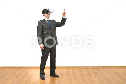 The man with a virtual reality glasses gesturing on the white wall background Stock Photos