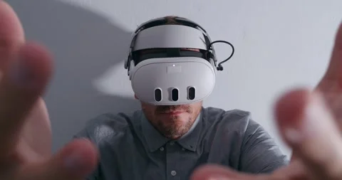 Man with Virtual Reality glasses touching the air looking on hands in vr. Stock Footage 259447568
