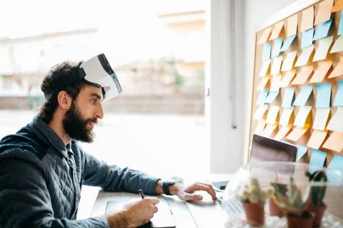 Man with Virtual Reality Glasses working working with graphics tablet and laptop Stock Photos