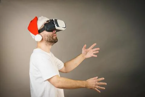 Man in virtual reality goggles and santa hat Stock Photos
