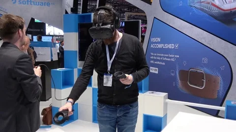 Man in virtual reality headset and handheld controllers developed by HTC Vive on Stock Footage 74109450