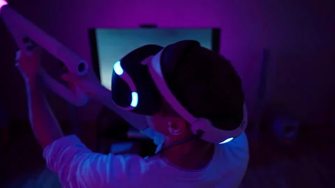Man with virtual reality headset and joystic is playing game Stock Footage 178887459