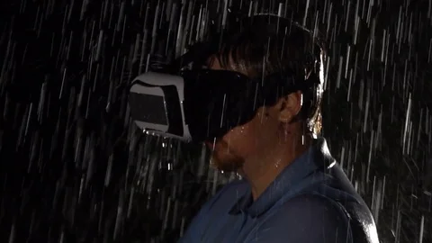 Man in virtual reality headset, entertainment, play game in the rain. VR Stock Footage 80433749
