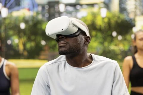 Man with virtual reality headset looking upward during yoga session Stock Photos
