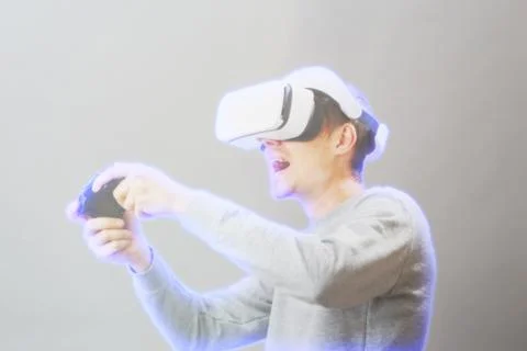 Man with virtual reality headset is playing game. Image with hologram effect. Stock Photos
