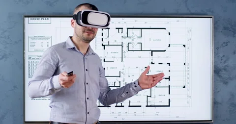 Man in virtual reality headset stands against wall with TV Stock Footage 243831242