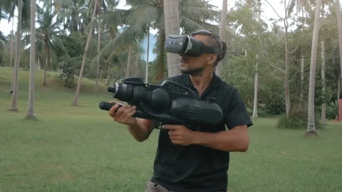 Man in virtual reality headset with weapon in the jungle running in slow motion Stockbeeldmateriaal 89506216