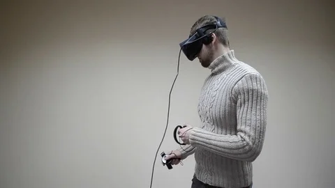 Man in a virtual reality helmet on his head and with joystick in their hands Stock Footage 72873580