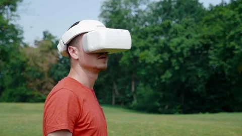 Man in a virtual reality helmet is studying a virtual game. 4K footage Video stock 135298971