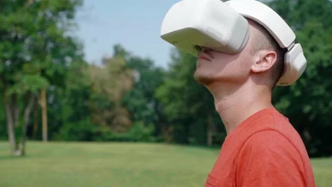 Man in a virtual reality helmet turns his head left and up Stock Footage 135299562
