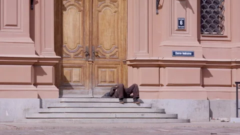 Man in visible distress lying on steps in central Riga, capital of Latvia. Stock Footage 309553021