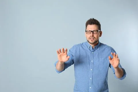 Man with vision problems wearing glasses on grey background, space for text Stock Photos