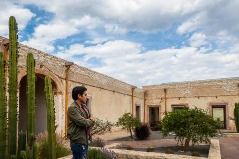 Man visiting the old rustic model school with cactus in Mineral de Pozos Gu.. Stock Photos