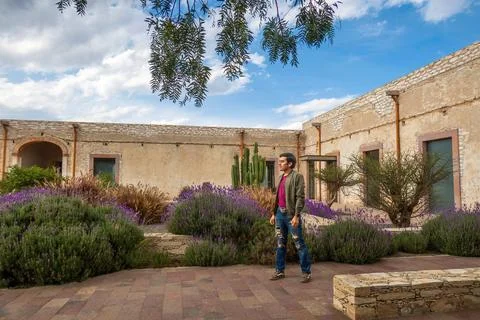 Man visiting the old rustic model school with cactus in Mineral de Pozos Gu.. Foto stock