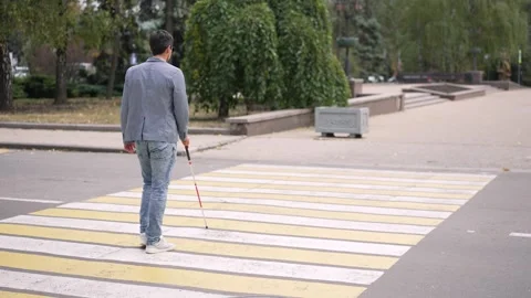 Man with Visual Impairment Walking Across a Crosswalk 스톡 동영상 290851385
