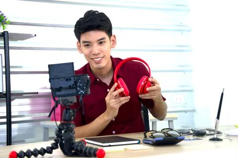 A man vlogger presenting a headphone bluetooth in livestream Stock Photos