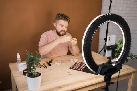 Man vlogging about make up and beauty products. Male shooting a makeup tutorial 스톡 사진