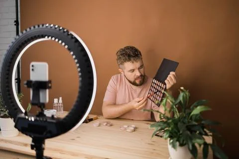 Man vlogging about make up and beauty products. Male shooting a makeup tutorial 写真素材