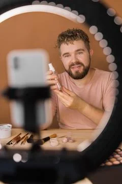 Man vlogging about make up and beauty products. Male shooting a makeup tutorial Stock Photos