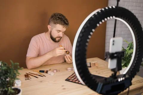 Man vlogging about make up and beauty products. Male shooting a makeup tutorial Foto stock