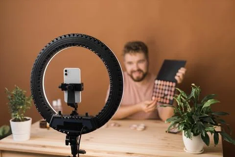 Man vlogging about make up and beauty products. Male shooting a makeup tutorial Fotos Stock