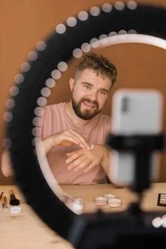  Man vlogging about make up and beauty products. Male shooting a makeup tu... Stock Photos