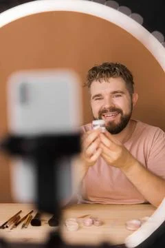  Man vlogging about make up and beauty products. Male shooting a makeup tu... Stock Photos