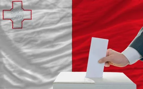 Man voting on elections in malta in front of flag Stock Photos
