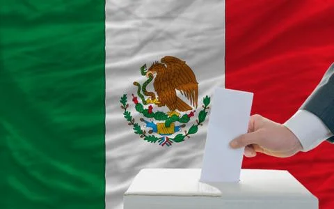 Man voting on elections in mexico in front of flag Stock Photos