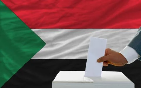 Man voting on elections in sudan in front of flag Stock Photos