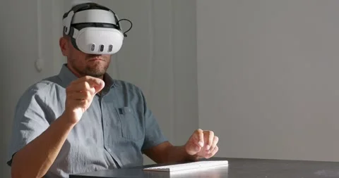 Man in VR goggles typing keyboard, working in virtual or mixed reality. Stock Footage 258879552