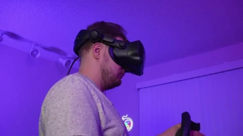 Man in VR headset controlling with controller precisely interacting with game Stock Footage 334089981