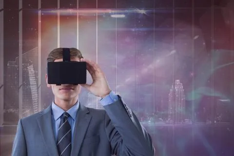 Man in VR headset looking against galaxy and city background Stock Photos