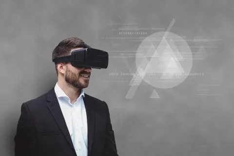 Man in VR headset looking at interface against grey background 写真素材