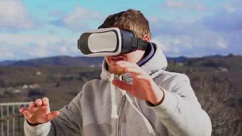 A man in VR headset looking up at the objects in virtual reality Stock Footage 73688402