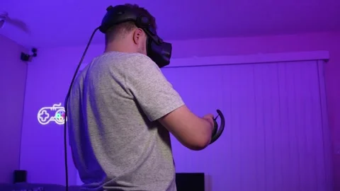 Man in VR headset reaching forward with controller playing virtual reality Stock Footage 334090152