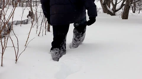 Man wades knee-deep through snow - winter garden Vidéo 1083407